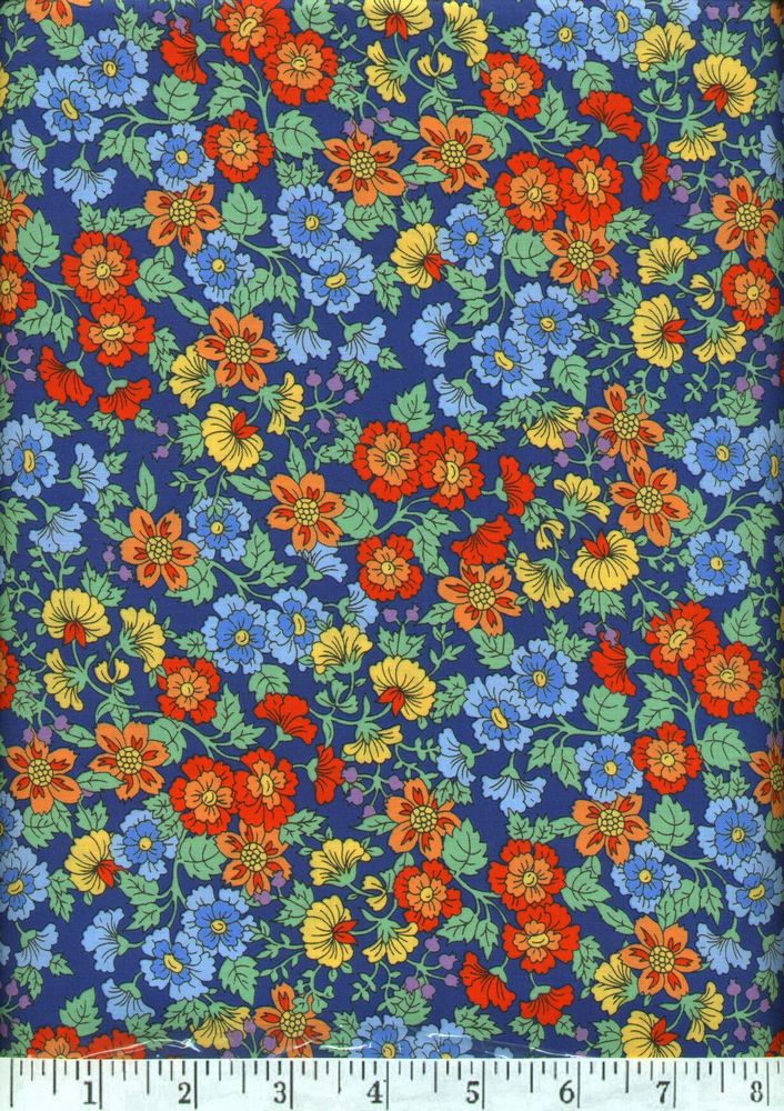 This beautiful print has small flowers in orange, gold and blue on a darker blue background.